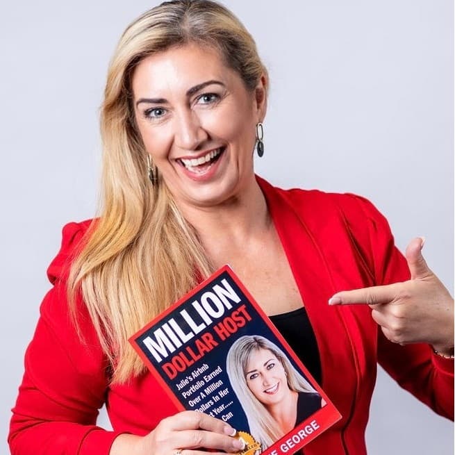 Julie George holding her book, Million Dollar Host